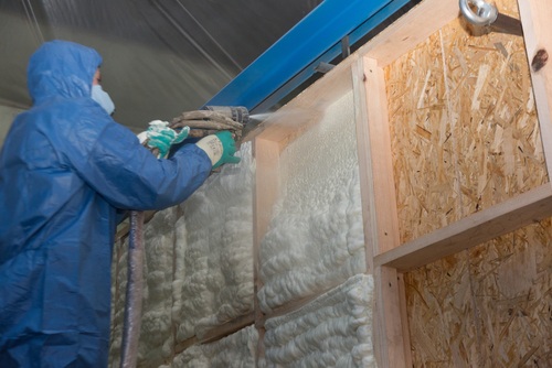 spraying an even layer of insulation to a wall